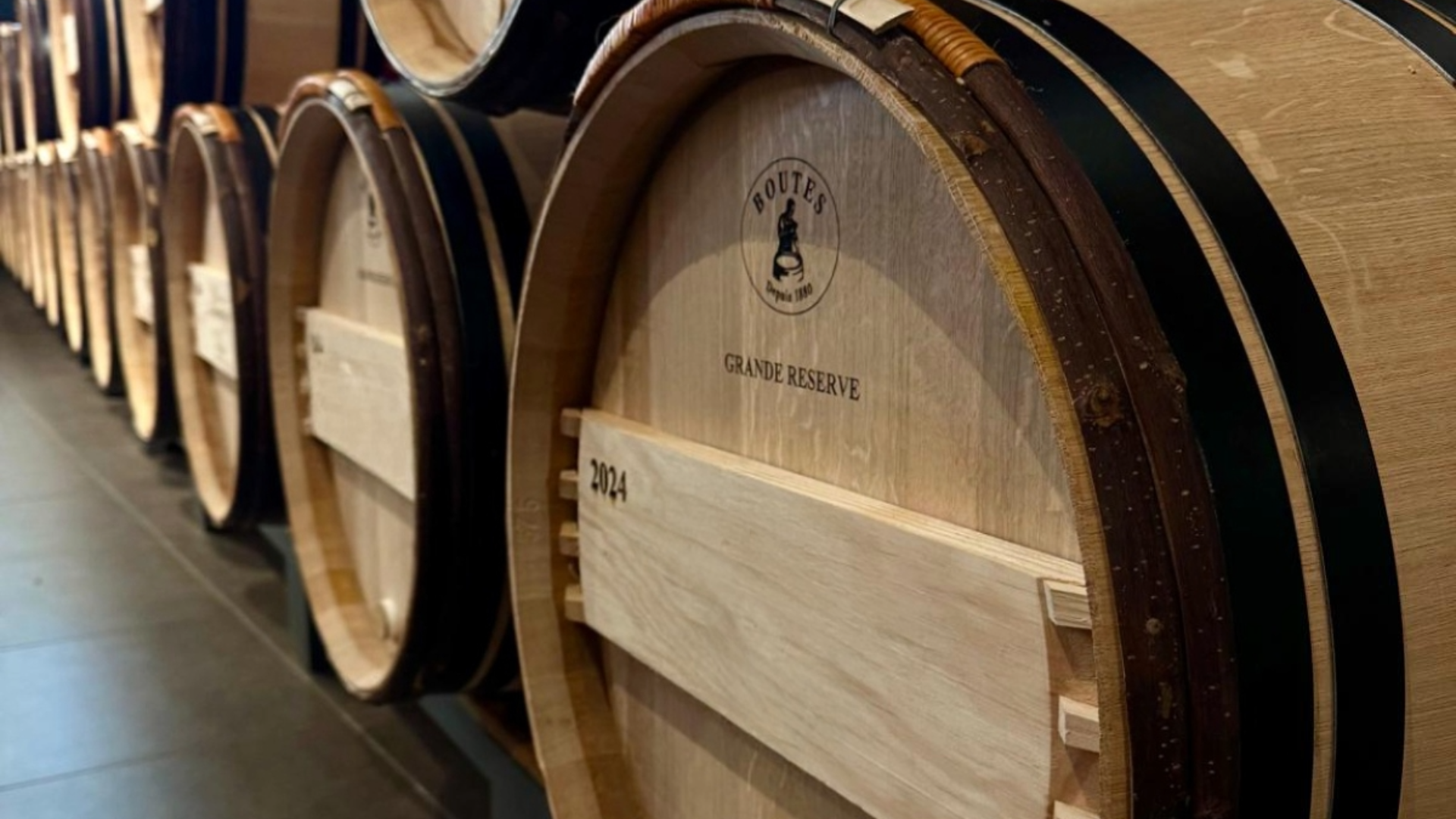 Rangée de barriques en chêne marquées “Grande Réserve – 2024”, signature de la Tonnellerie Boutes, symbole de son savoir-faire traditionnel et constant.